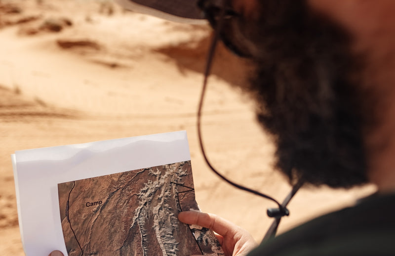 Bearded man outdoors, looking at map