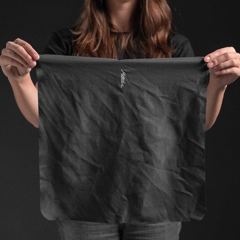 Woman on black background holding out NanoDry Trek Towel