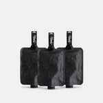 3 charcoal FlatPak Toiletry Bottles on light gray background