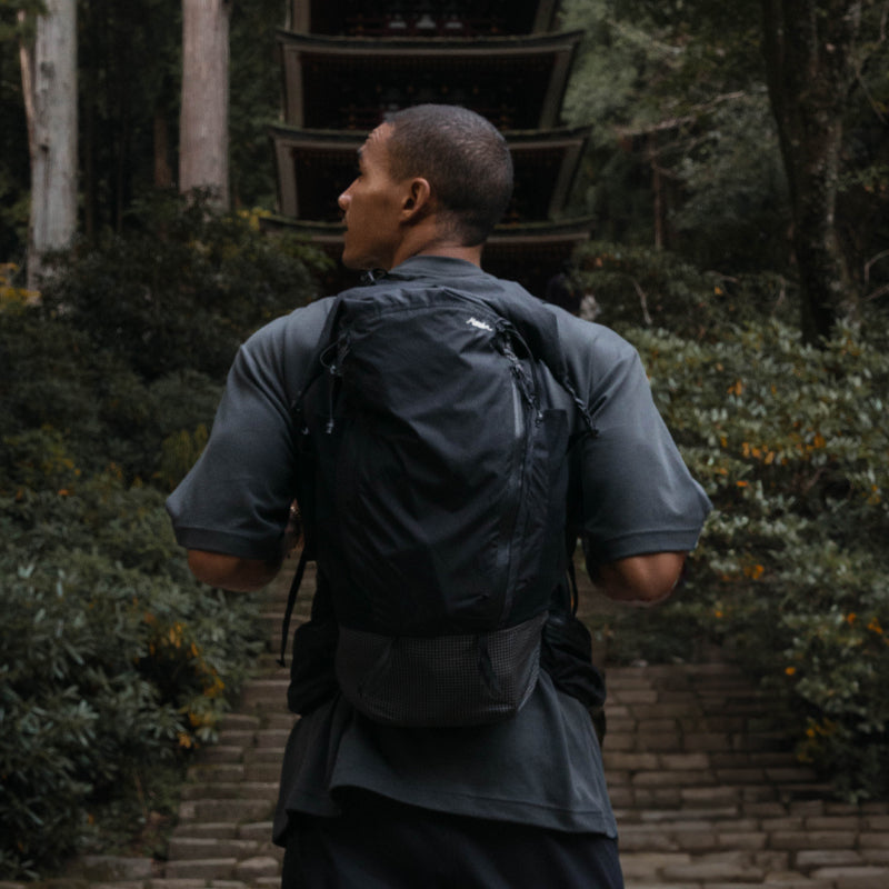 Man facing a Japanese pagoda wearing a Matador backpack 