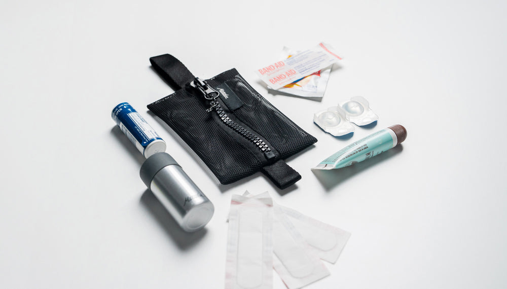 small mesh bag on white background surrounded by bandaids and other first aid items