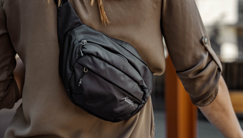 Close up view of On-Grid Hip Pack being worn across a woman's back