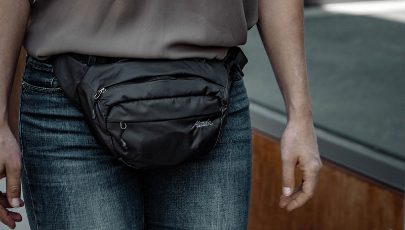 Close up view of woman wearing On-Grid Hip Pack across the front of her waist