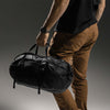 Man holding duffle from carry handles