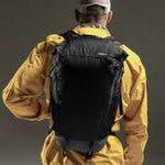 Man in wearing backpack on black background