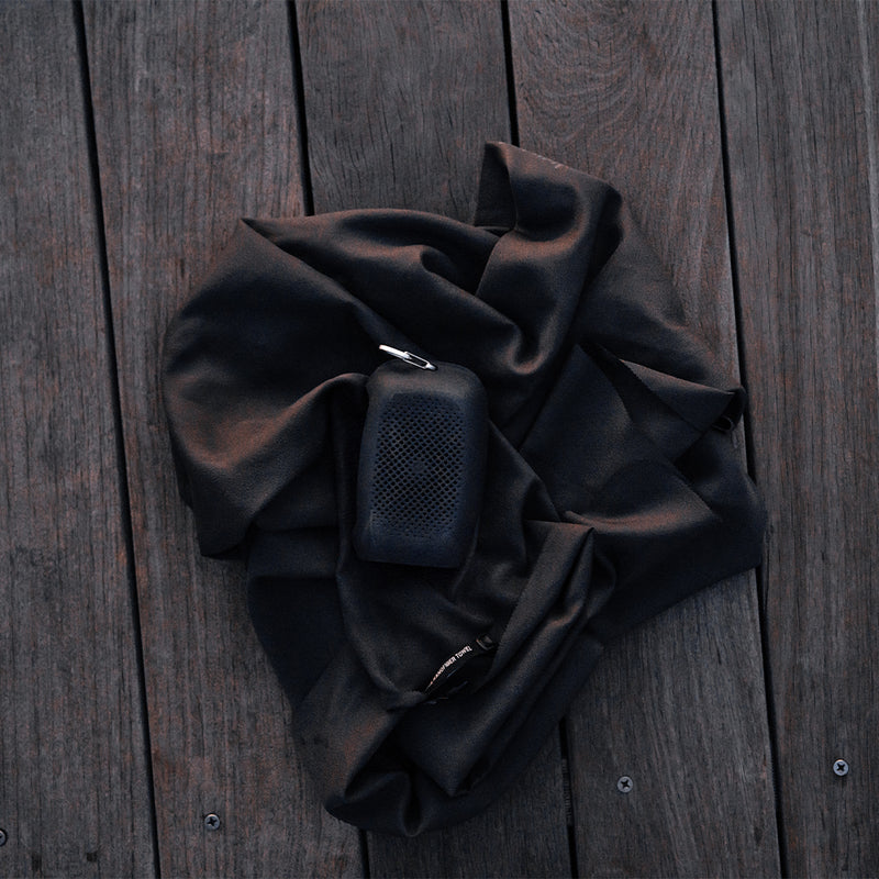 Charcoal NanoDry towel and silicone case laying out on wooden dock