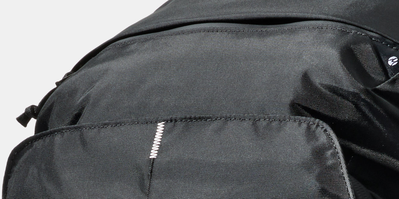 White Switchback Stitch™ on a black backpack with a light grey background