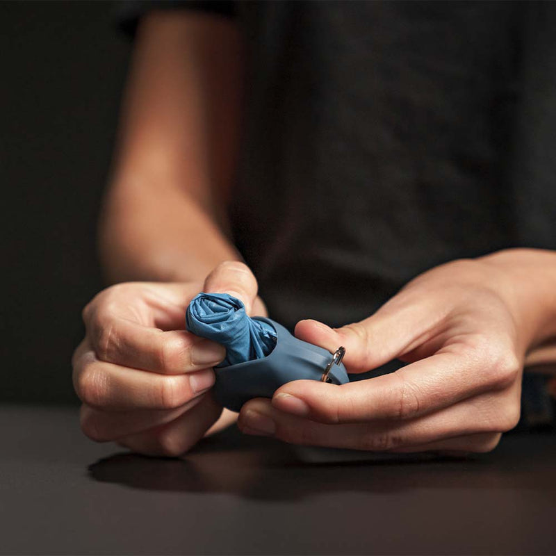 Hands pulling blue Droplet out of its silicone case
