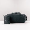 black duffle and packed up duffle on light gray background
