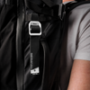 White gear tag hanging off black backpack worn by man