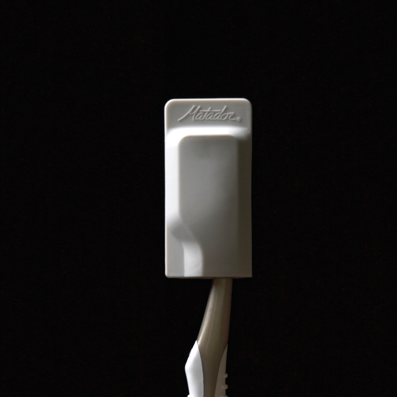 Light Gray toothbrush cap on gold toothbrush in front of black background