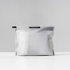 back view of white zipper toiletry case on light gray background