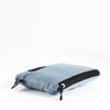 packed up slate blue towel laying down on white background