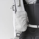 front view of white speed stash on white backpack strap
