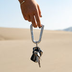 woman holding silver betalock with keys on desert background