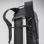 Black backpack sternum strap being used as a luggage handle passthrough