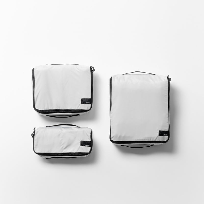 top view of white small, medium, and large packing cubes on white background