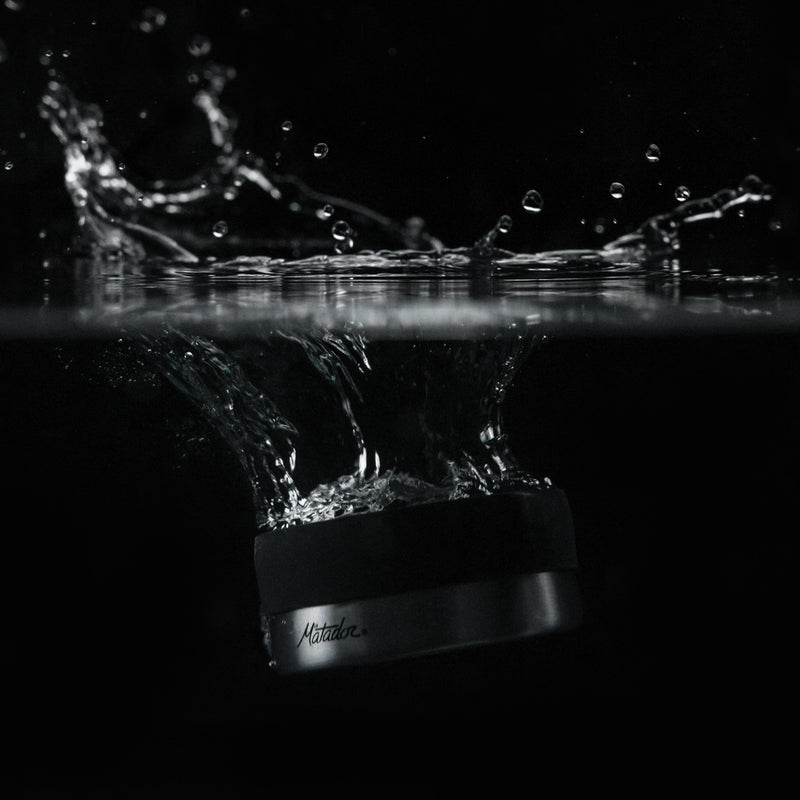 100mL canister splashing into water with black background