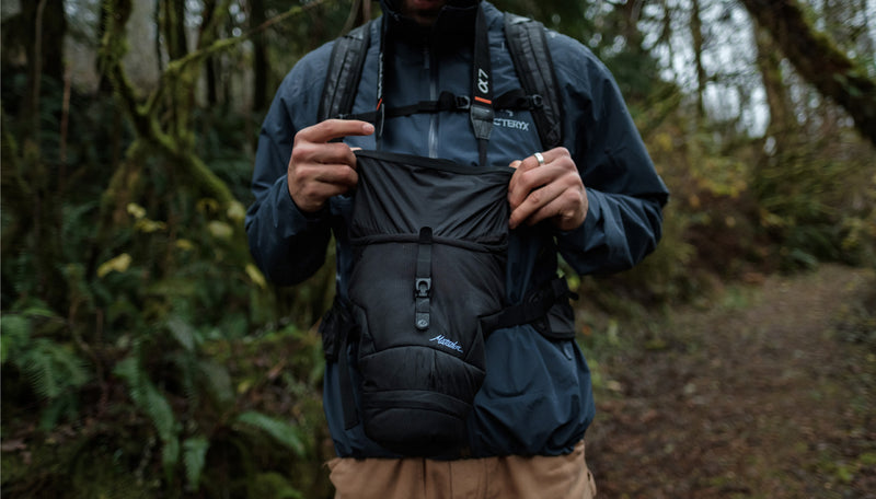 Man rolling Camera Base Layer closed in rainy weather