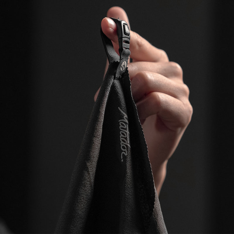 Close up view of NanoDry Towel hang loop, hanging from finger