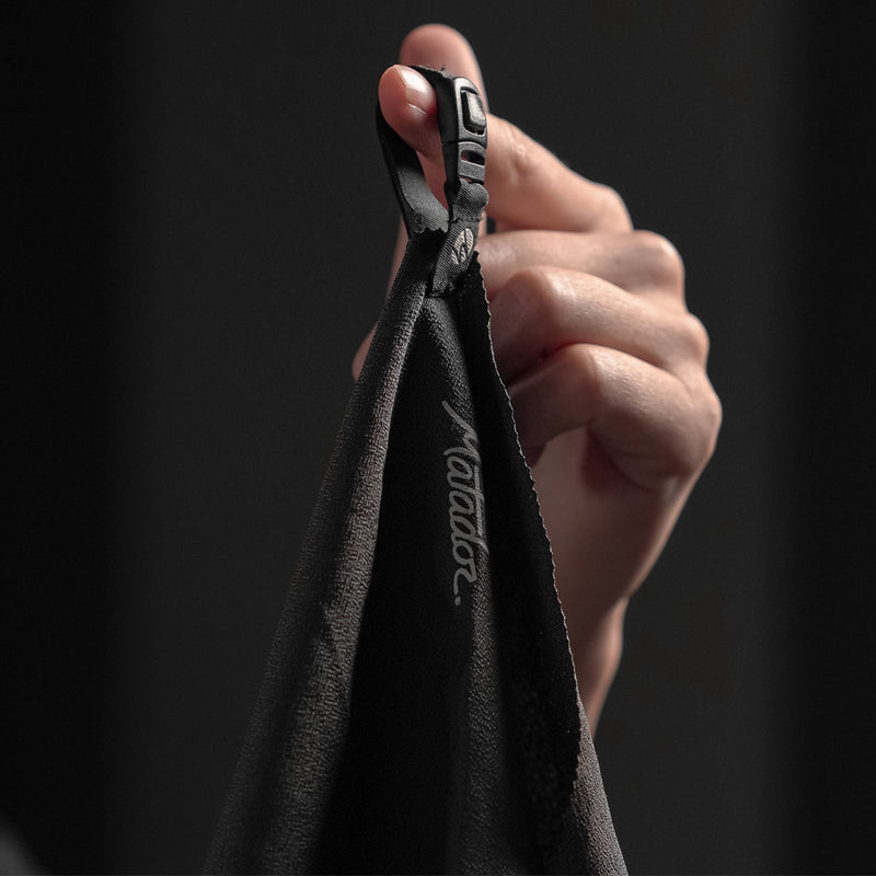 Close up view of NanoDry Towel hang loop, hanging from finger