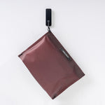 front view of garnet zipper toiletry case hanging from black hook on white wall