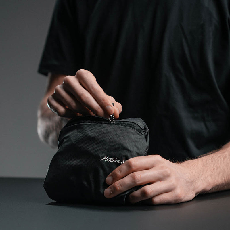 Hands holding packed up On-Grid Backpack