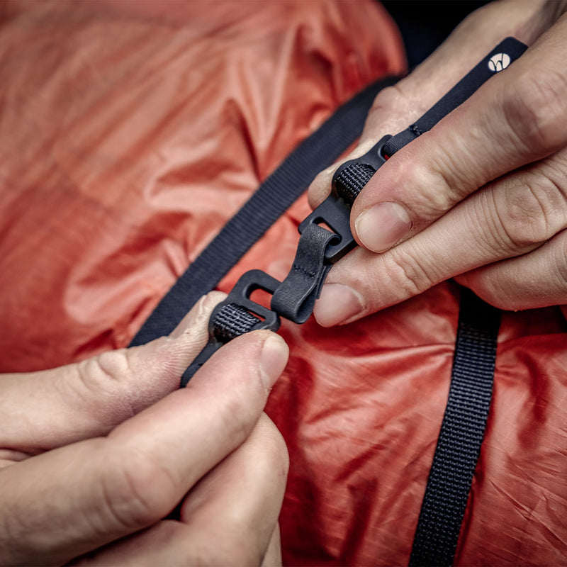 Hands connecting the Better Tether around orange tarp