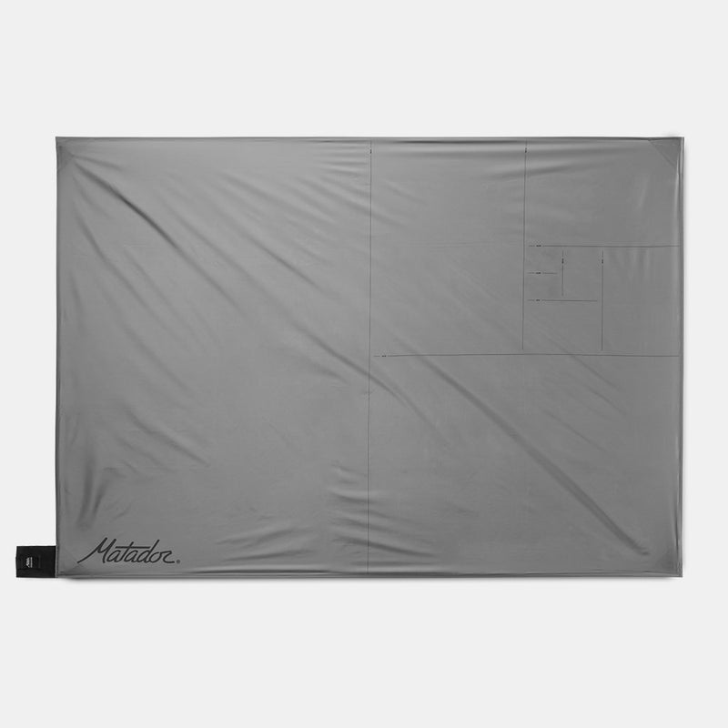 Pocket Blanket laid out flight on light gray background
