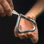 hand holding close up view of metal carabiner with key inserted