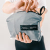 Close up view of hands unzipping Slate Blue backpack pouch
