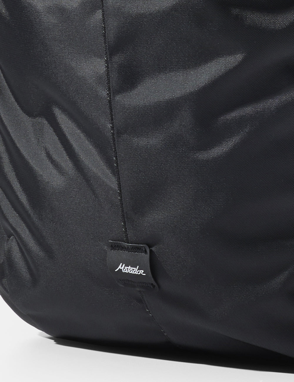 close up of matador logo sewn onto black bag