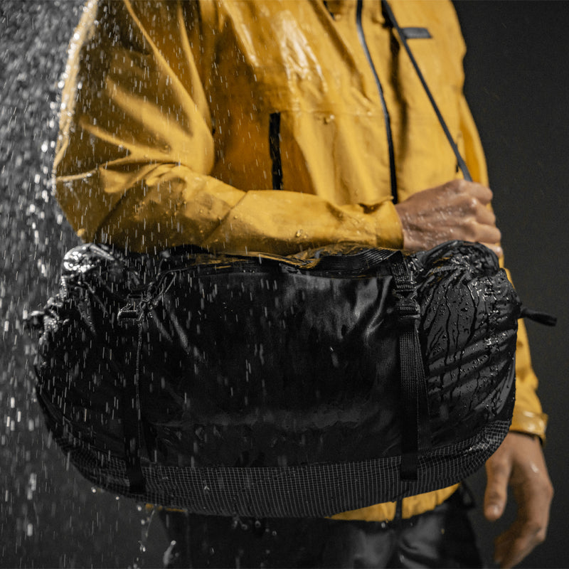 Person in yellow jacket wearing Freefly Duffle in the rain