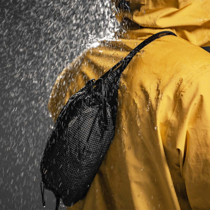 Person in yellow jacket wearing Freerain Hip Pack in the rain
