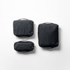 top view of black small, medium, and large packing cubes on white background