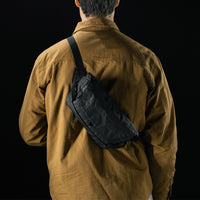 man in black studio wearing black sling bag across his back