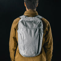 man on black studio background wearing white backpack