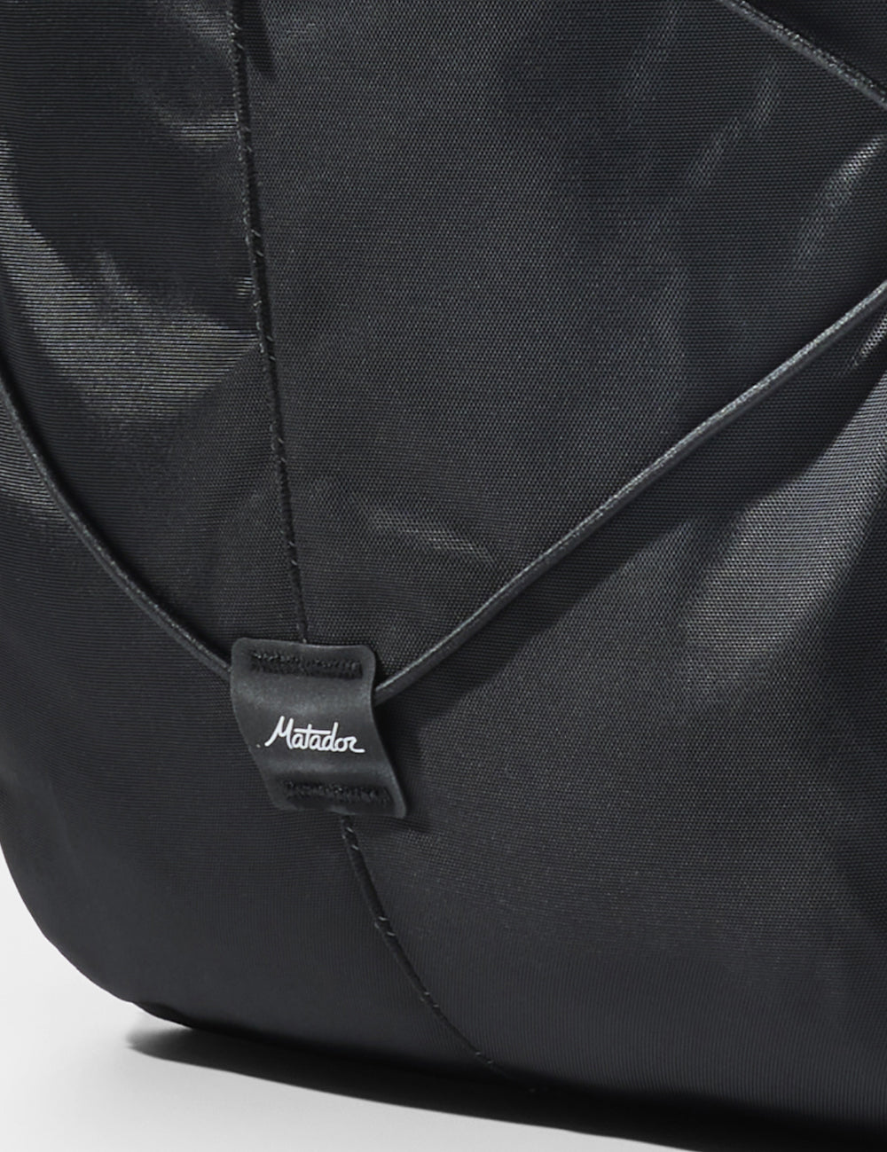 close up of matador logo sewn onto black bag