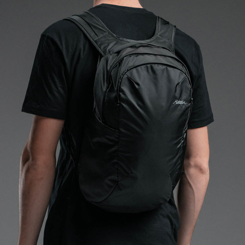 Man on gray background wearing On-Grid Backpack
