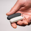 Close up view of hand holding both black and white silicone earplug cases