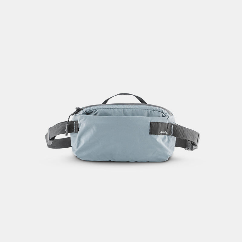 front view of slate blue sling bag on light gray background