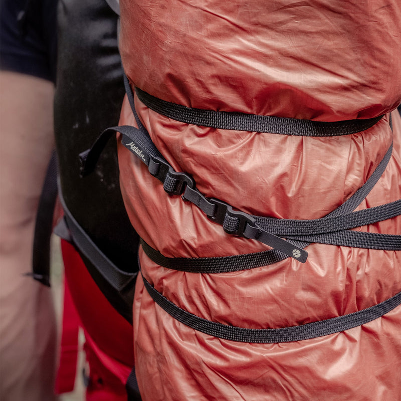 Better Tether wrapped around large orange tarp on a backpack