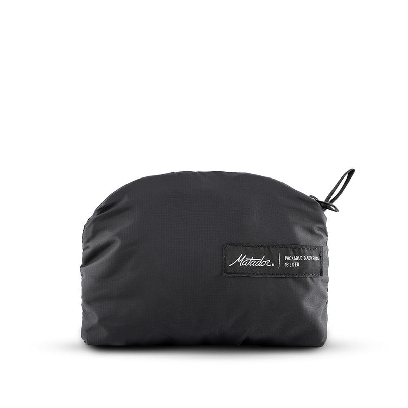 Packed up black backpack on white background