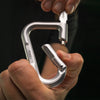 hand holding silver betalock on black background, demonstrating the key and deadbolt lock