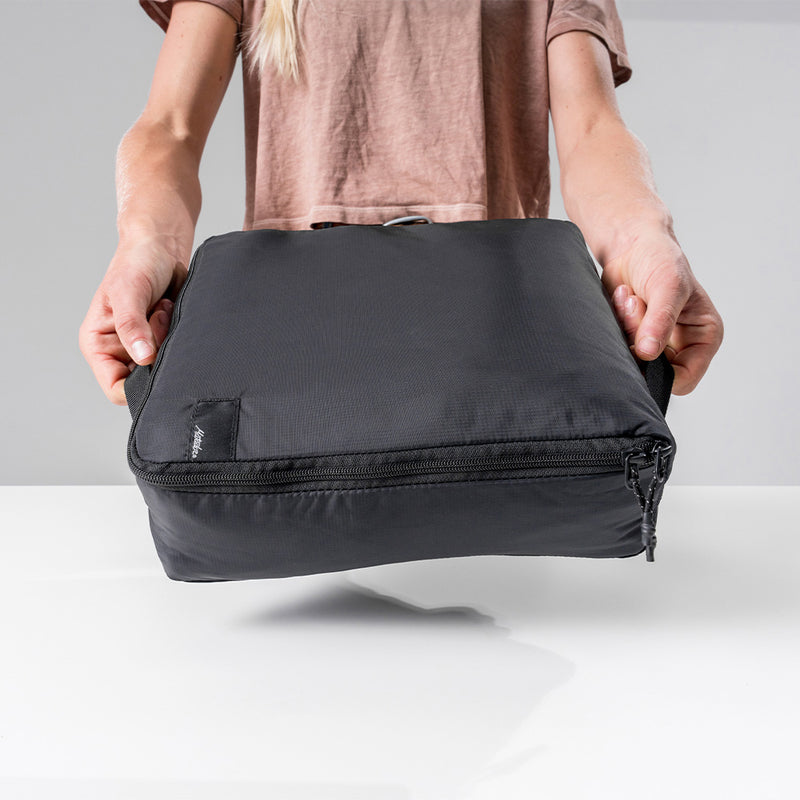 woman holding large black packing cube