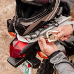 person locking motorcycle helmet to motorcycle with betalock and accessory cable