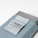 close up view of slate blue Pocket Blanket on light gray background