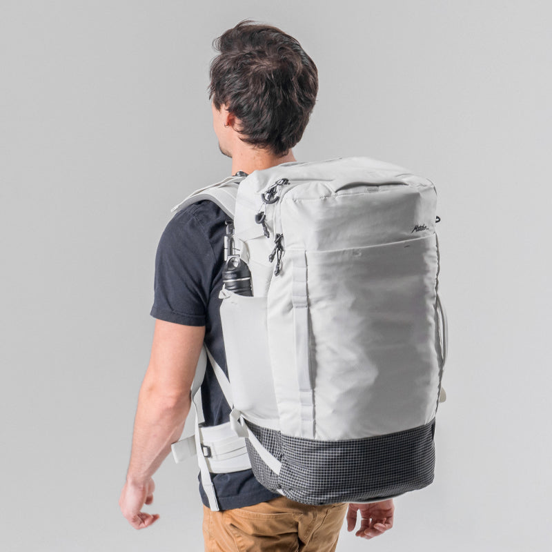 3/4 back view of man wearing white globerider45 on light gray background