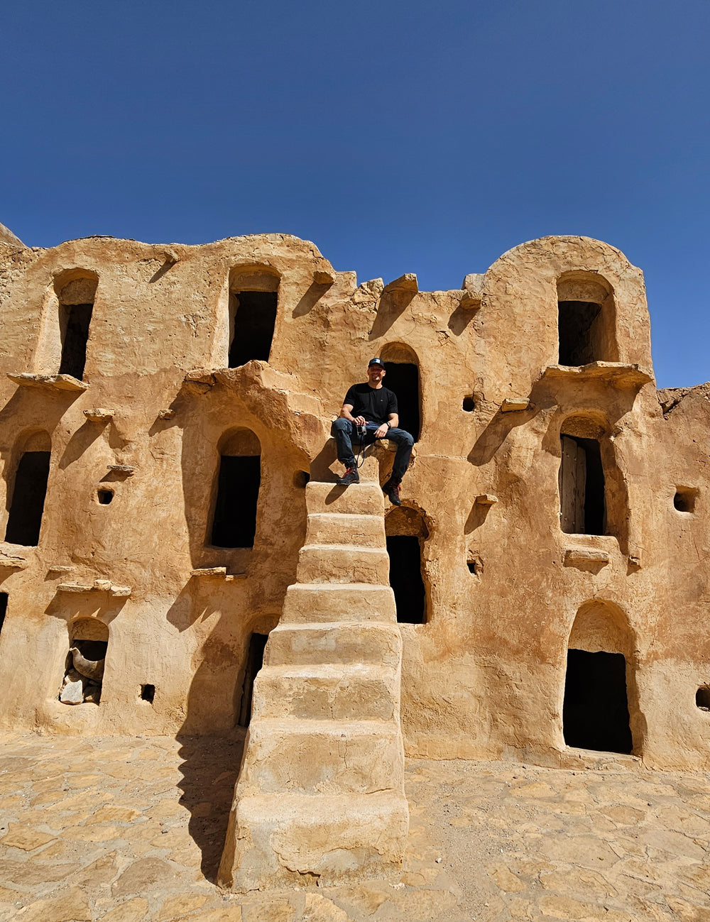 Man sitting on steps of ancient stone village