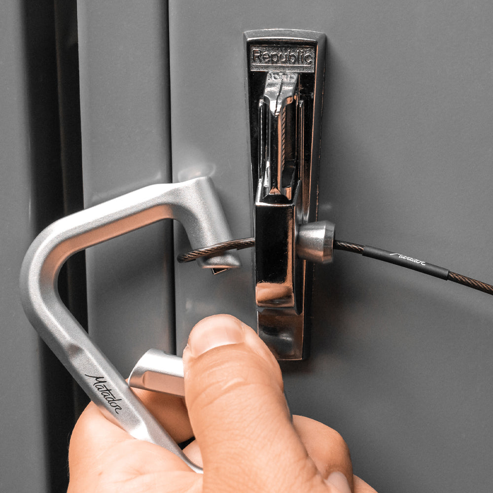 Hands placing accessory cable through locker and securing with betalock carabiner